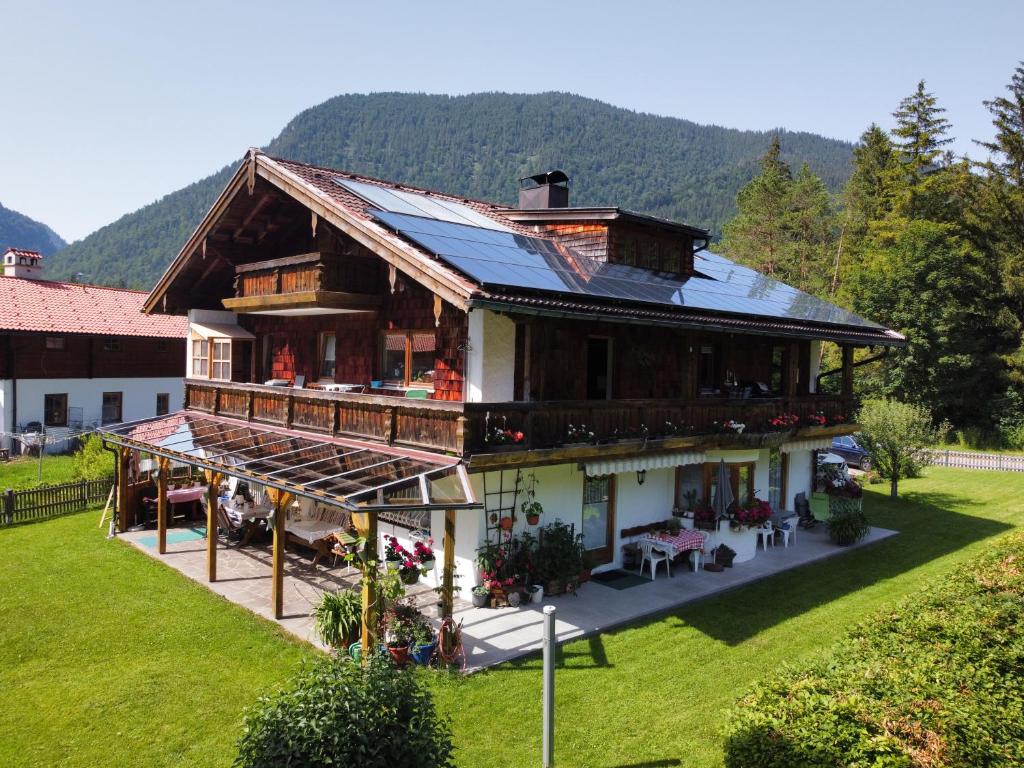 une vue aérienne sur une maison avec des montagnes en arrière-plan dans l'établissement Haus Stiafei, à Schneizlreuth