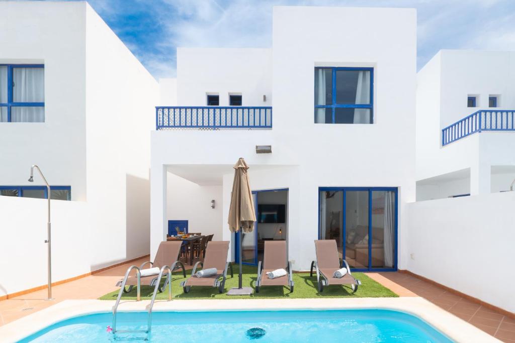 uma villa com uma piscina e uma casa em Luxury 3-bedroom villa with private pool in Marina Rubicon, Playa Blanca, Lanzarote em Playa Blanca