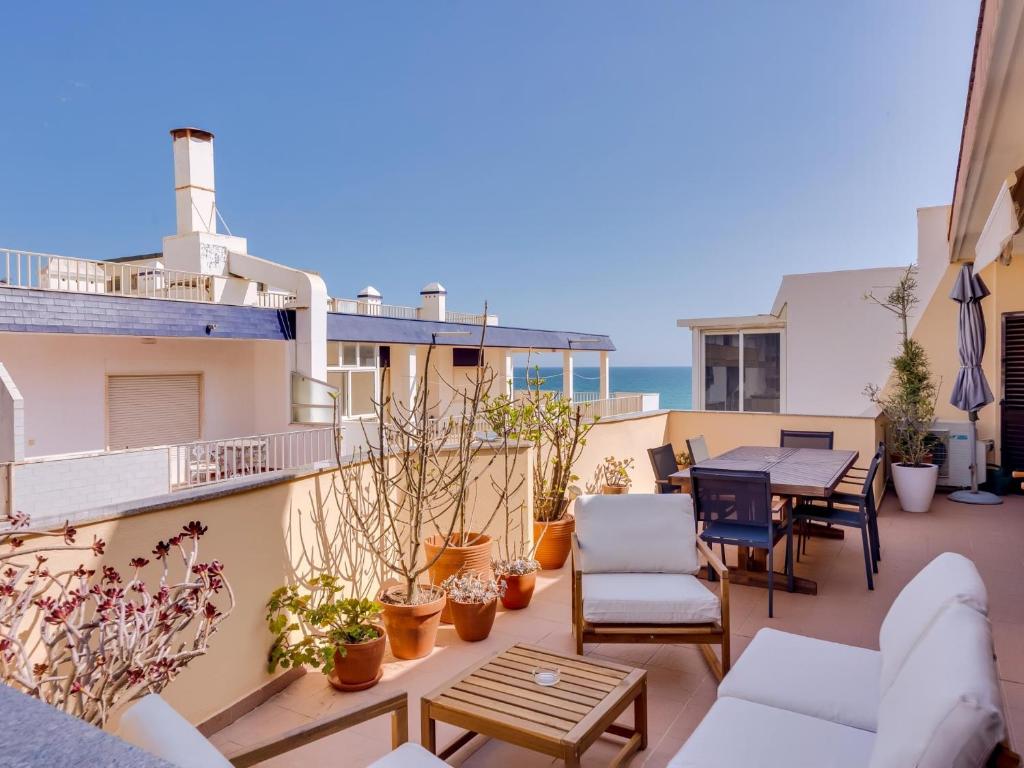 een patio met een tafel en stoelen op een balkon bij AL - Quarteira Terrace Penthouse in Quarteira