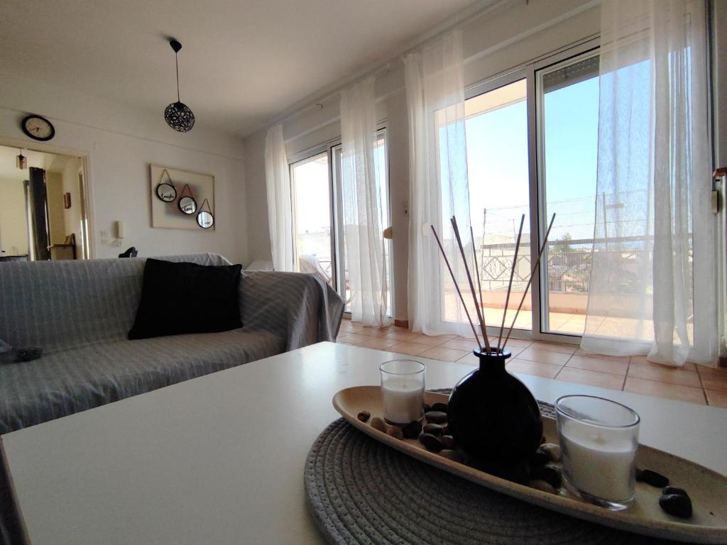 een woonkamer met een tafel met een vaas erop bij Penthouse View in Preveza