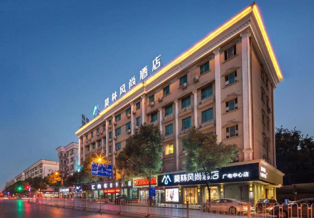 a large building on a city street at night at Morninginn, Radio and Television Center Xianglong Metro Station in Xingsha