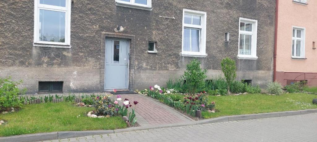 a garden with flowers in front of a building at Apartament w Centrum in Nysa