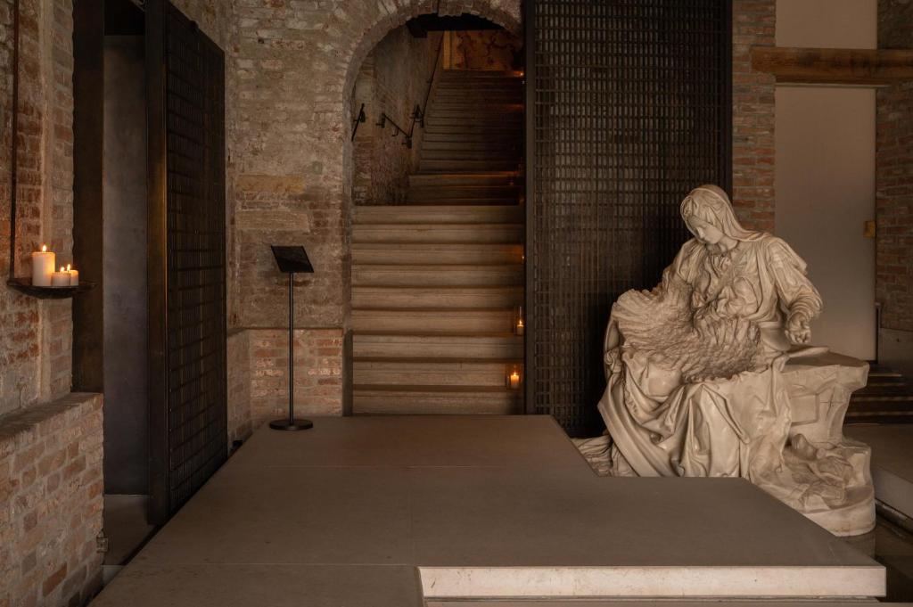 Una statua di una donna seduta su una scala di The Venice Venice Hotel a Venezia