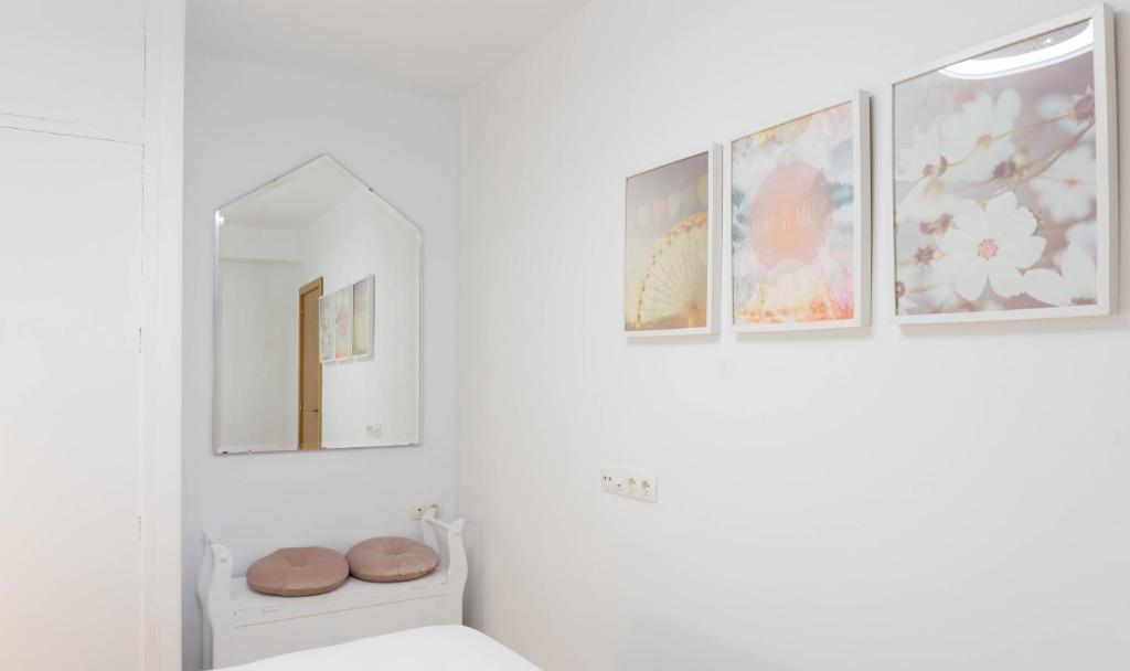 łazienka z lustrem i zdjęciami na ścianie w obiekcie Apartment Caleta Beach Málaga w Maladze