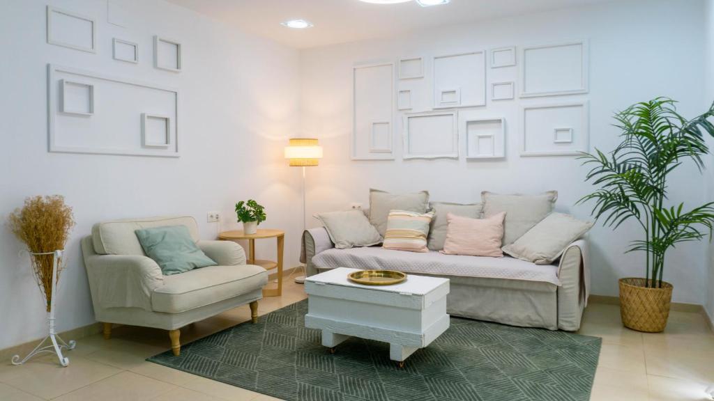 salon z kanapą i krzesłem w obiekcie Apartment Caleta Beach Málaga w Maladze
