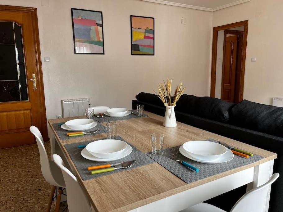 - une table à manger avec des assiettes et des ustensiles dans l'établissement Amplio y luminoso apartamento, à Sagonte
