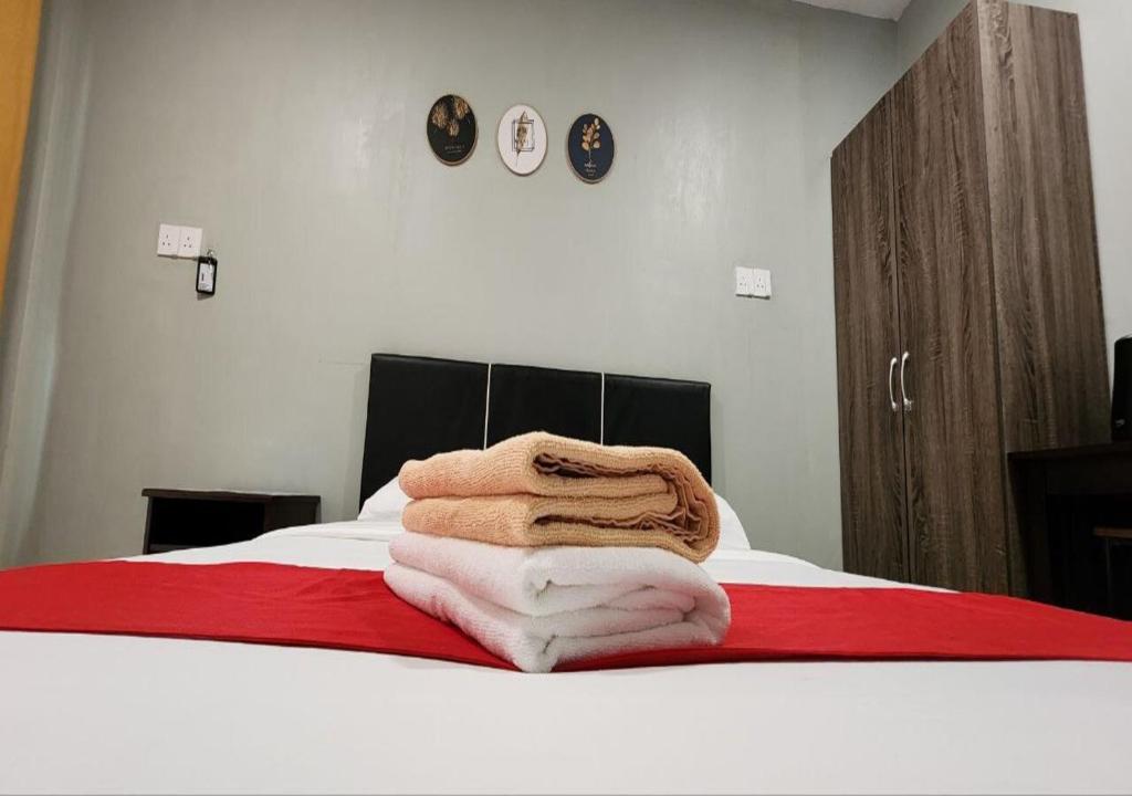 a pile of towels sitting on top of a bed at Grapevine Garden in Kota Kinabalu