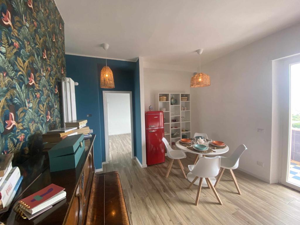 eine Küche mit einem Tisch und Stühlen sowie einem roten Kühlschrank in der Unterkunft Casa Vacanze Nene in Minturno