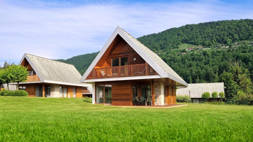 ein großes Haus auf einem grünen Rasen in der Unterkunft Apartment HORTENZIJA near Terme Topolšica in Topolšica