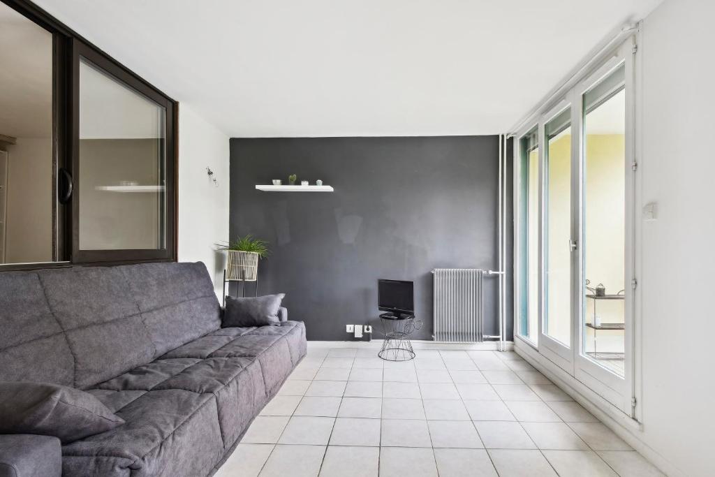 ein Wohnzimmer mit einem Sofa und einem TV in der Unterkunft Le Glatigny- Chesnay in Le Chesnay