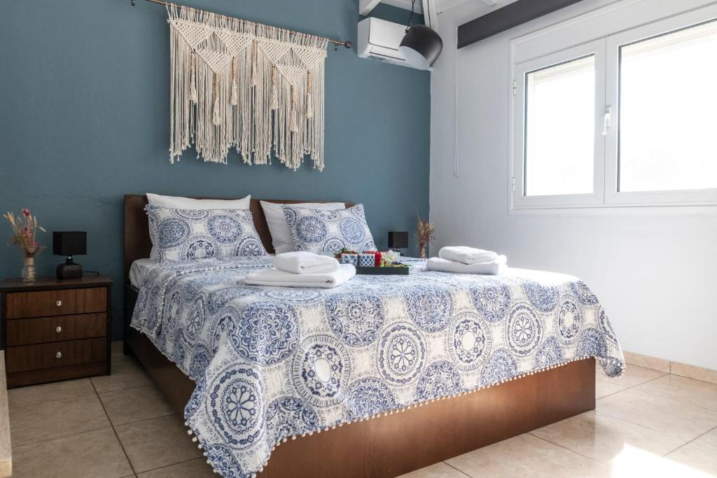 um quarto com uma cama com uma parede azul em Tsitsanis Home em Tympáki