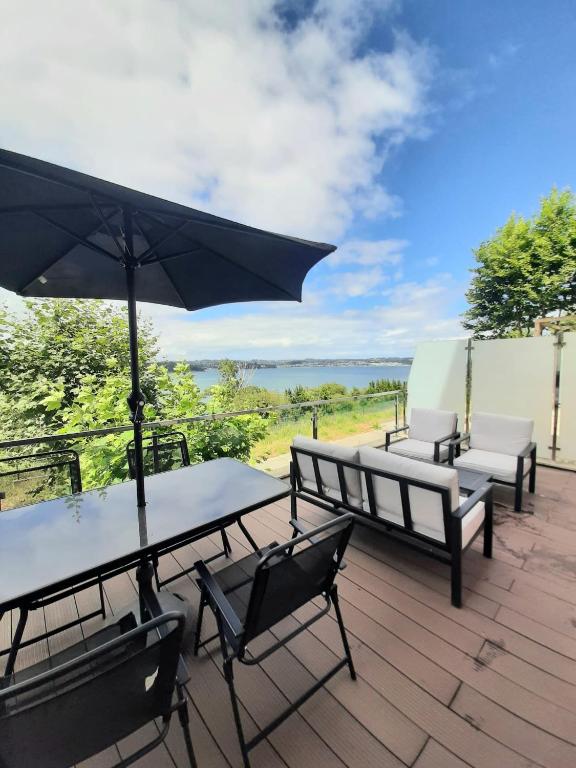 米尼奧的住宿－Super vistas Miño I，一个带桌椅和遮阳伞的庭院