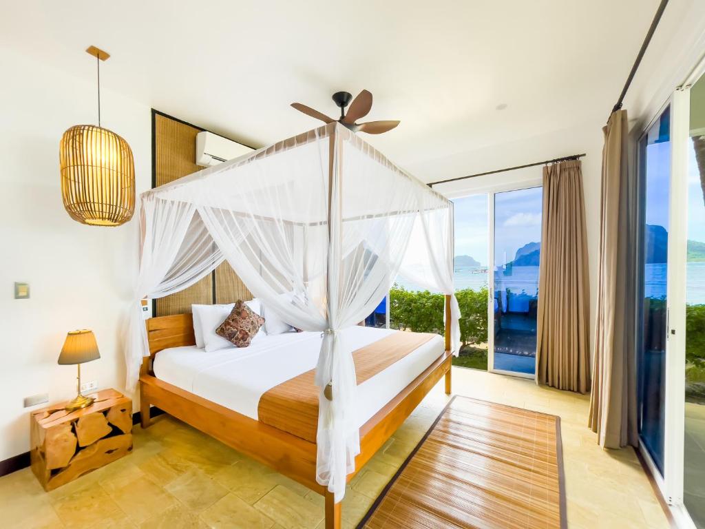 a bedroom with a bed with a canopy at Cadlao Resort and Restaurant in El Nido