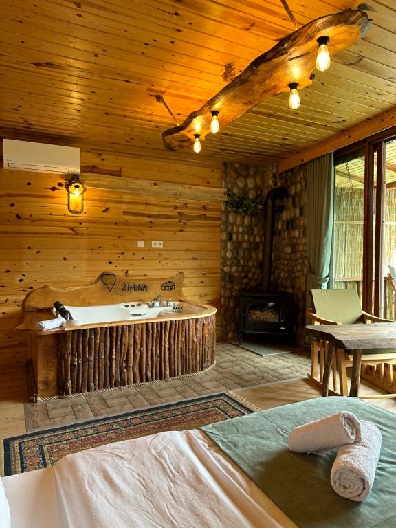 um quarto com uma banheira e uma cama num camarote em Zifona Bungalov em Çamlıhemşin