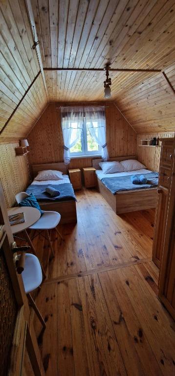 a large room with two beds and a window at Willa NA SKARPIE - Z WIDOKIEM NA JEZIORO in Olsztynek