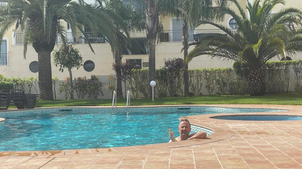 a child laying in a swimming pool in a house at Amazing 2 Bedroom Apartment near beach with pool in Lagos
