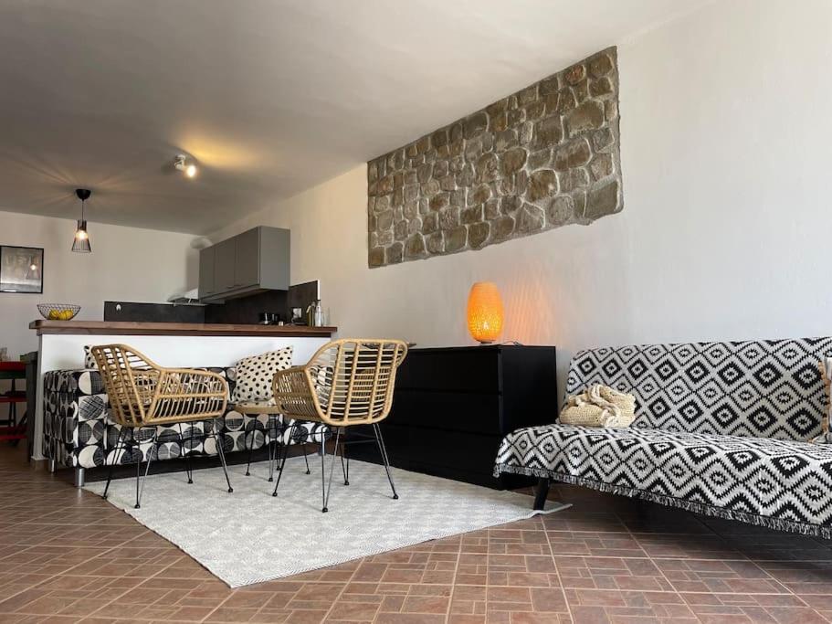 ein Wohnzimmer mit einem Sofa, einem Tisch und Stühlen in der Unterkunft Kalithea Studio 2 in Palekastro