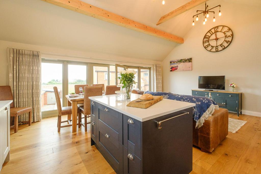 cocina y sala de estar con sofá y mesa en Alde Bay Farm - Lobster Pot, en Aldeburgh