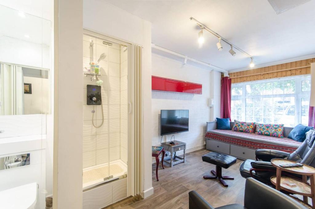 salon z kanapą i telewizorem w obiekcie Leeward Gardens With EnSuite w Londynie