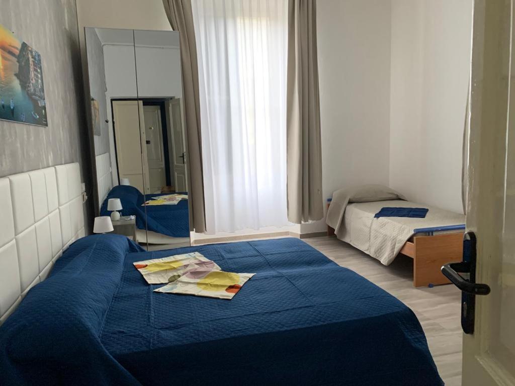 una camera con letto blu e specchio di Eden Hotel a Deiva Marina