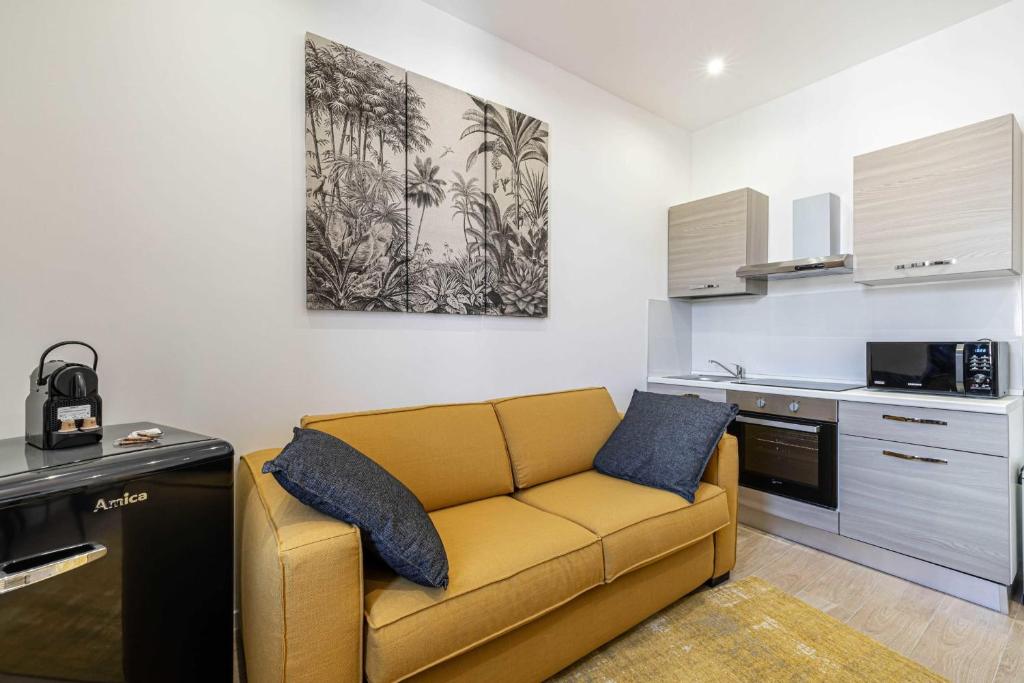 ein Wohnzimmer mit einer gelben Couch in einer Küche in der Unterkunft Sublime studio renovated - Cannes center in Cannes