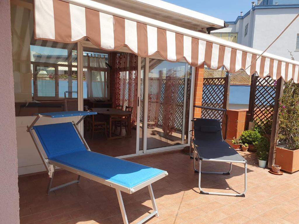 - une terrasse avec 2 chaises et un auvent dans l'établissement Attico Due Giugno, à Piombino