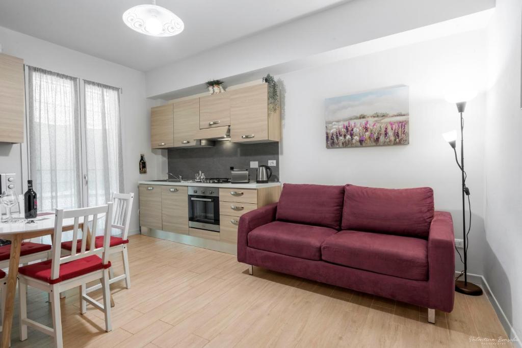 uma sala de estar com um sofá vermelho e uma cozinha em Wine Apartments Florence Masseto em Florença