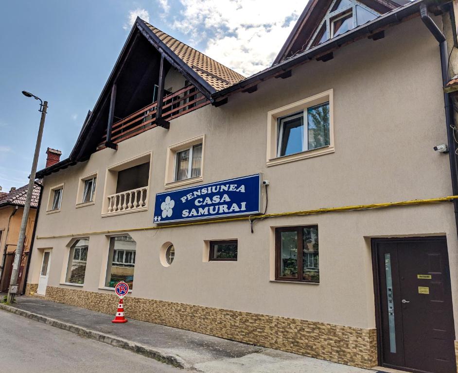 a building with a sign on the side of it at Pension Casa Samurai in Braşov