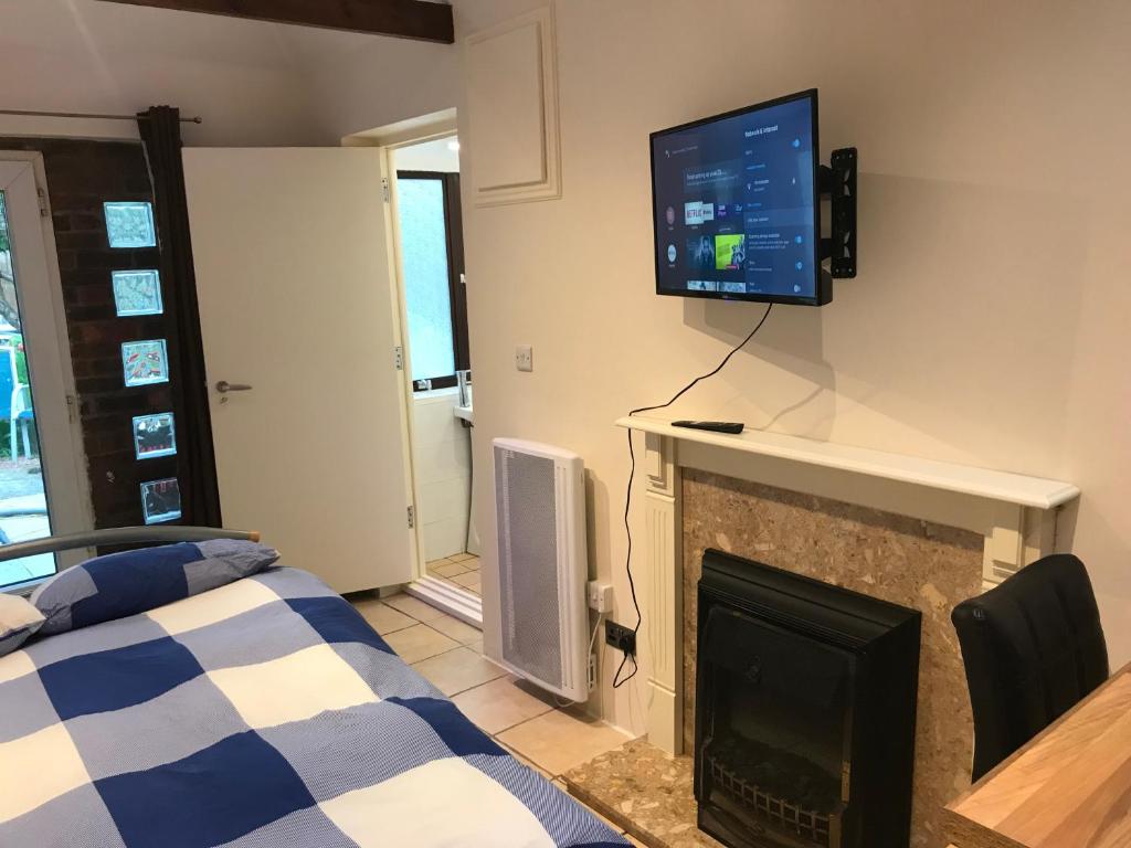 ein Wohnzimmer mit einem TV über einem Kamin in der Unterkunft Self contained annex in Bournemouth