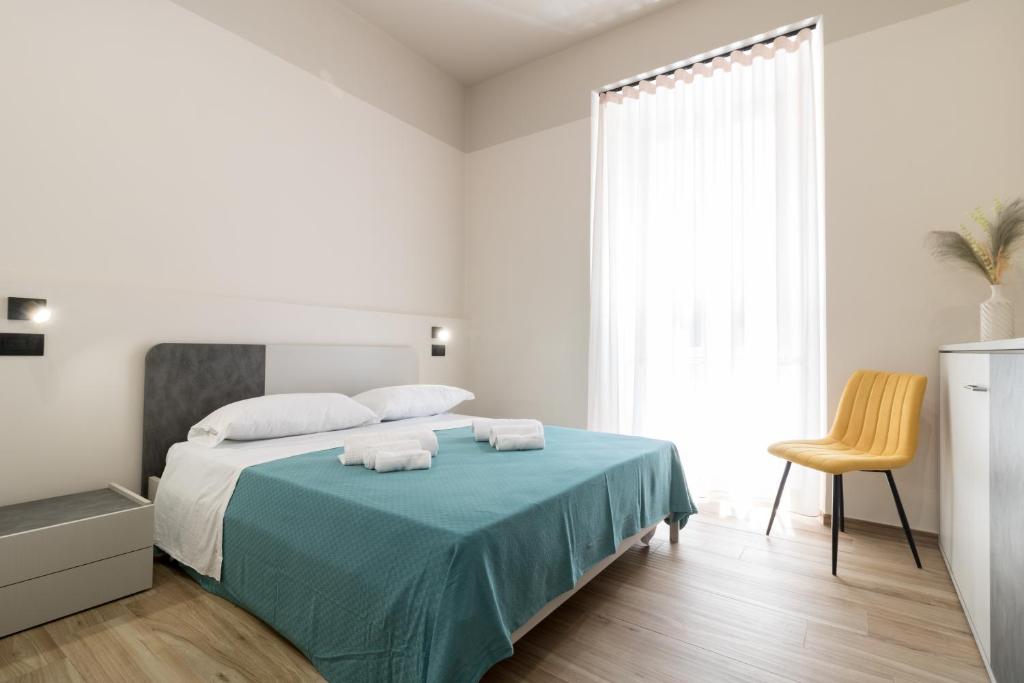 a white bedroom with a bed with two towels on it at Hispirya Rooms in Terracina