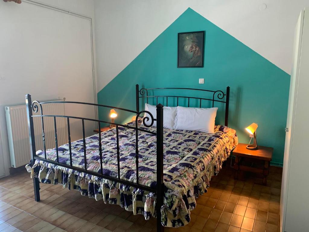 een slaapkamer met een bed met een blauwe muur bij Litsa's House in Neos Marmaras