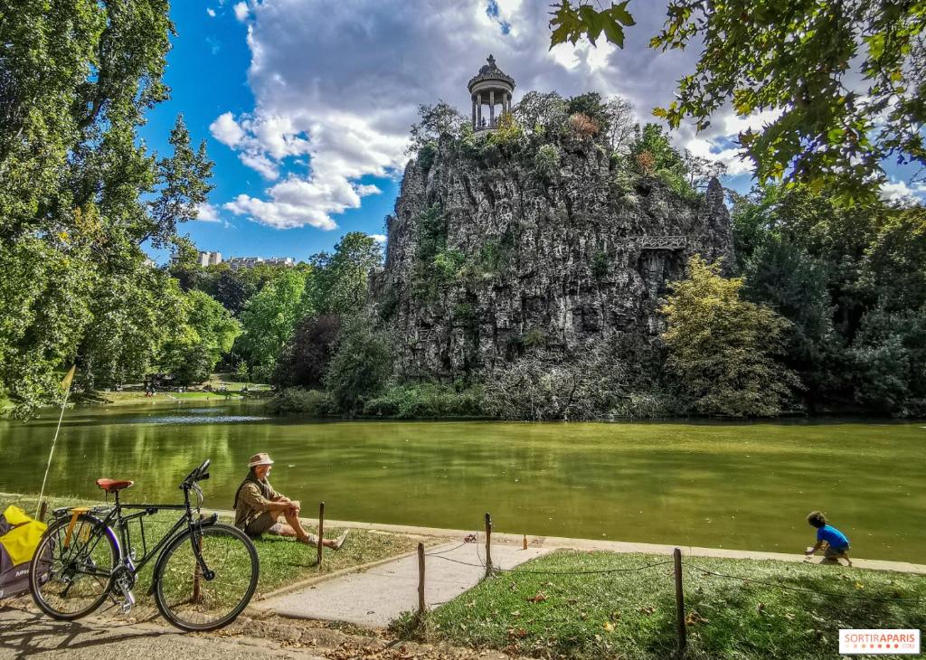 パリにあるAppartement Paris 11eの湖前の自転車の横に座る男