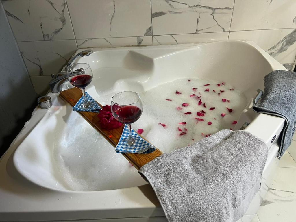 Villa Blacksea في Arnavutköy: كأسين من النبيذ في حوض الاستحمام مع الحلويات