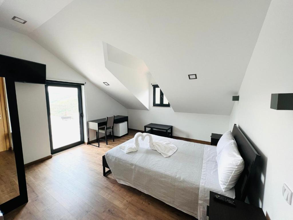 a bedroom with a bed and a large window at Quinta da Pinguinha - Douro in Armamar