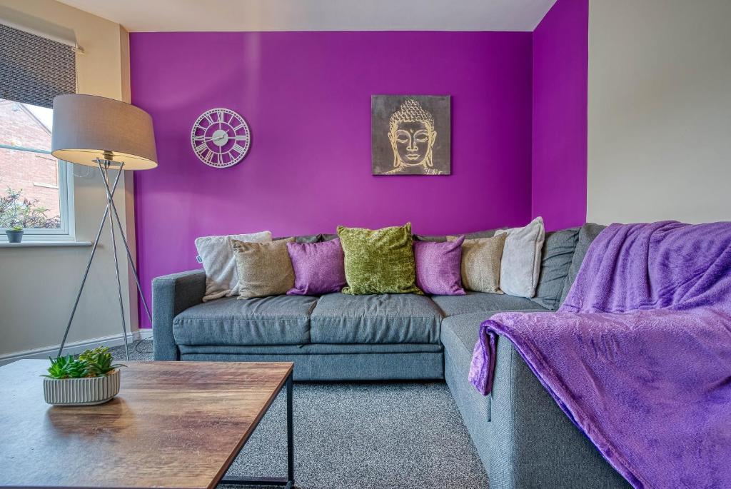 a purple living room with a couch and a table at Coventry Team Accomodation with Private Parking & WIFI in Parkside