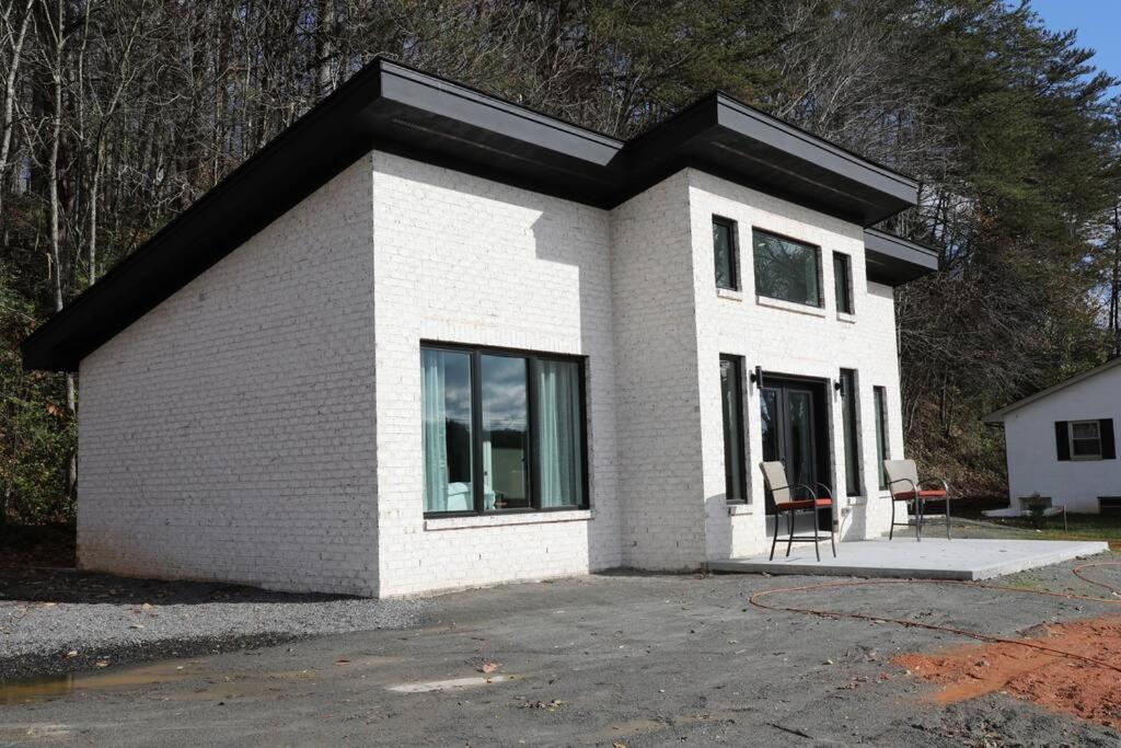 a small white house with a black roof at Golf Views Mount Airy in Mount Airy