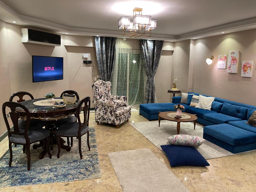 A Family Friendly Apartment في القاهرة: غرفة معيشة مع أريكة زرقاء وطاولة