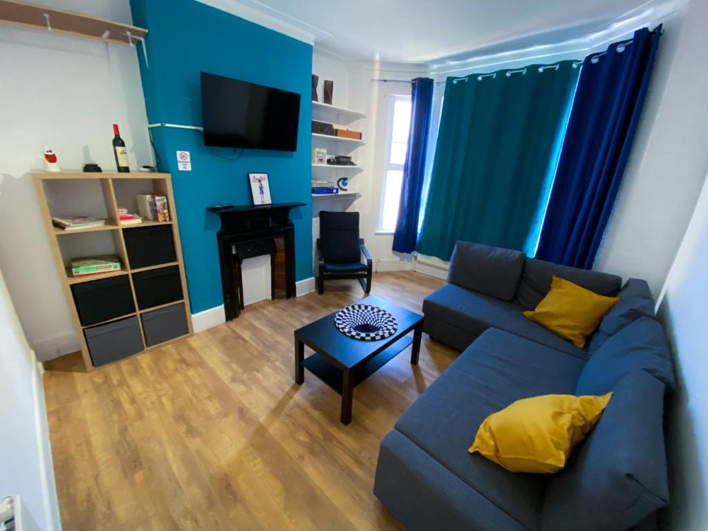 un soggiorno con divano e tavolo di 4 BEDROOM HOUSE PARKING & GARDEN NEAR CENTRAL LONDOn a Londra