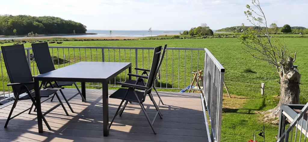 a table and chairs on a deck with a view of the ocean at Ferienwohnung Noor in Gelting