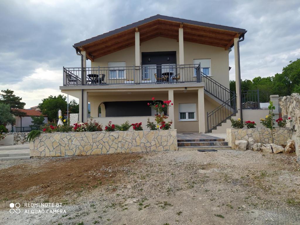 a house with a balcony and a porch at Apartmani Suzana in Crikvenica