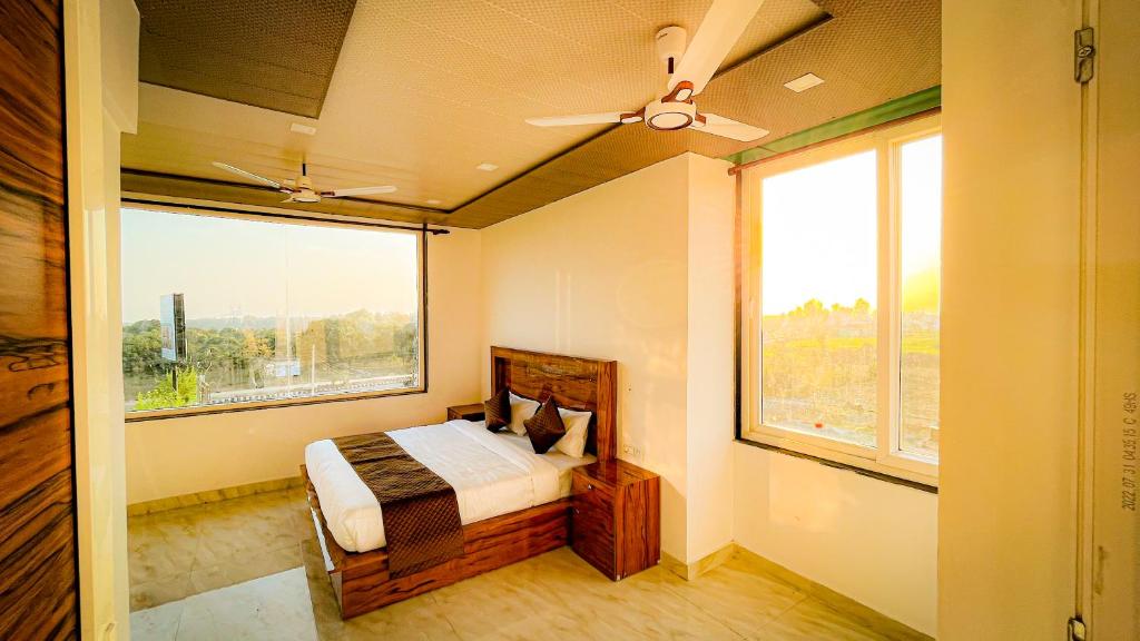 a bedroom with a bed and a large window at GREEN DANDI HOMESTAY in Rishīkesh