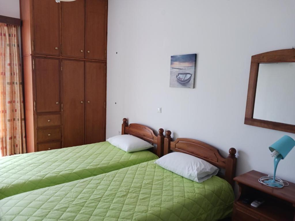 a bedroom with two twin beds and a mirror at P&G APARTMENTS in Naxos Chora