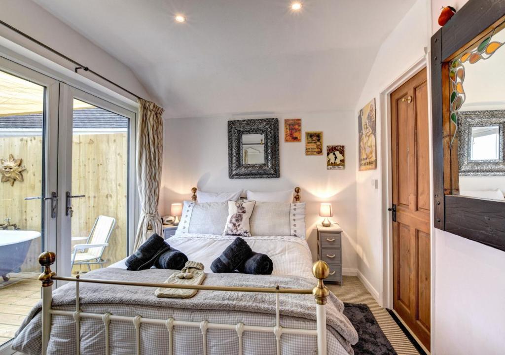 a bedroom with a bed and a large window at Dart View Cabin in Totnes