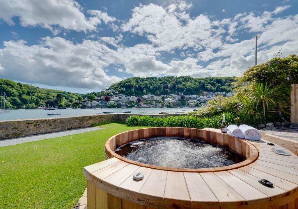 a wooden hot tub on a wooden deck with a view of a river at Ravenswell in Dartmouth