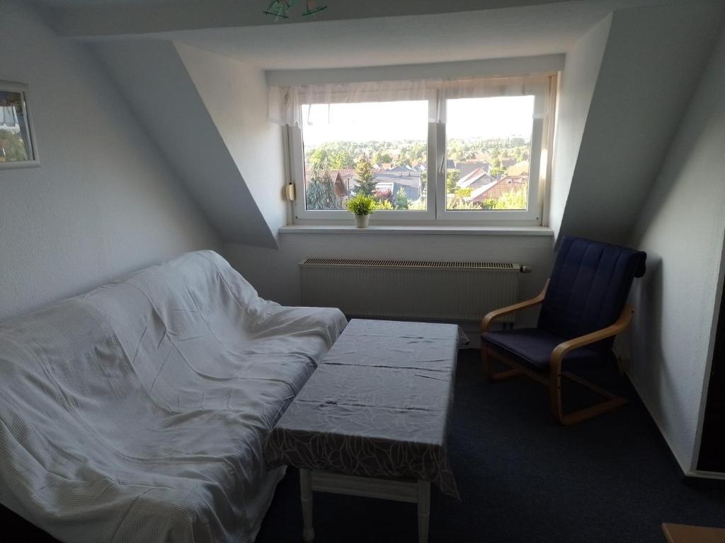 een kamer met een bed, een stoel en een raam bij Apartment Biesnitz in Görlitz