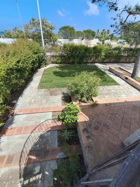 a garden with plants on a brick walkway at Villa Rossi in Polignano a Mare
