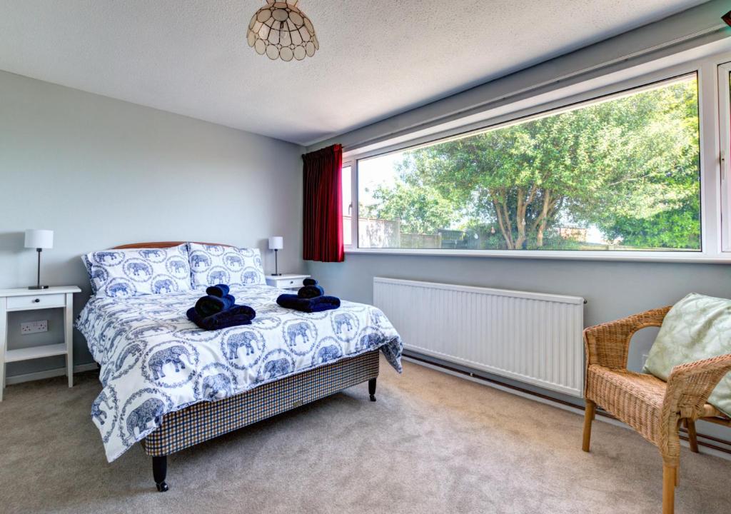 a bedroom with a bed and a large window at Bidwell Brook in Paignton