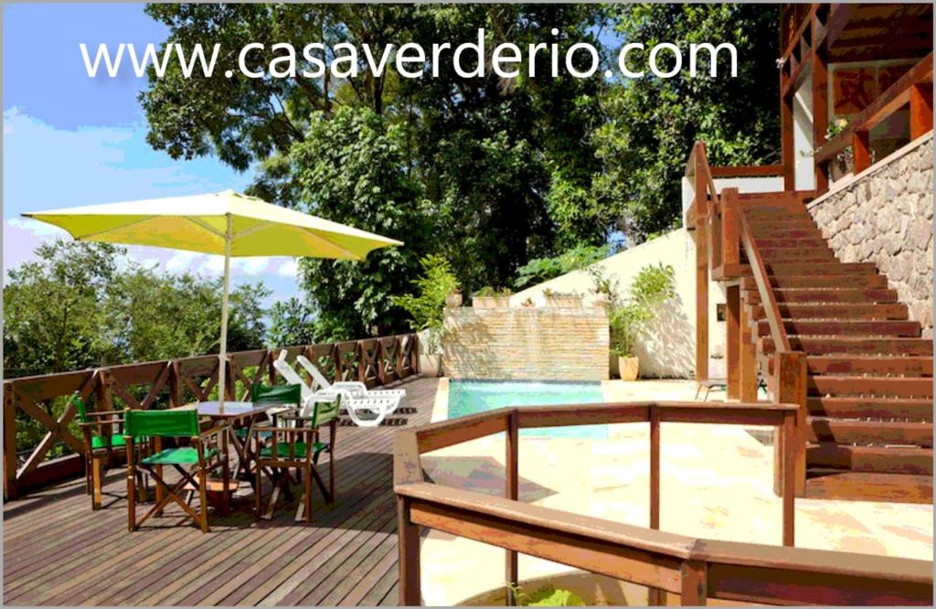 a patio with a table and chairs and an umbrella at Casa Verde in Rio de Janeiro