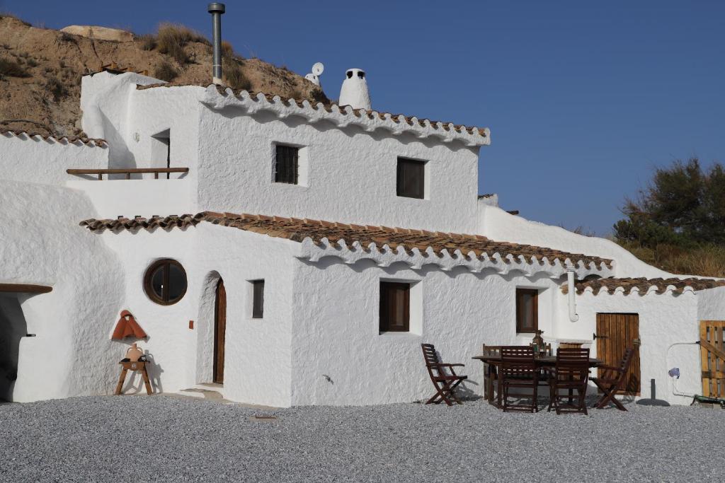 un edificio blanco con una mesa delante en Cuevas Azul en Baza