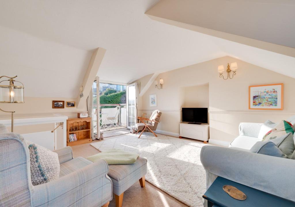 a living room with a couch and a tv at Jasmine Cottage in Brixham